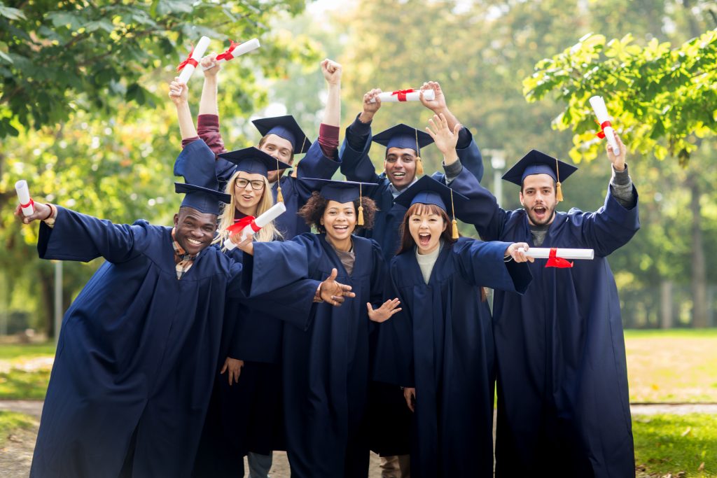 Graduates from the Class of 2019 in their caps and gowns brandishing their new diplomas