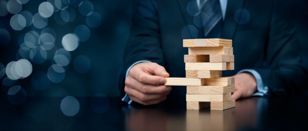 Businessman playing jenga game for gamification of training.