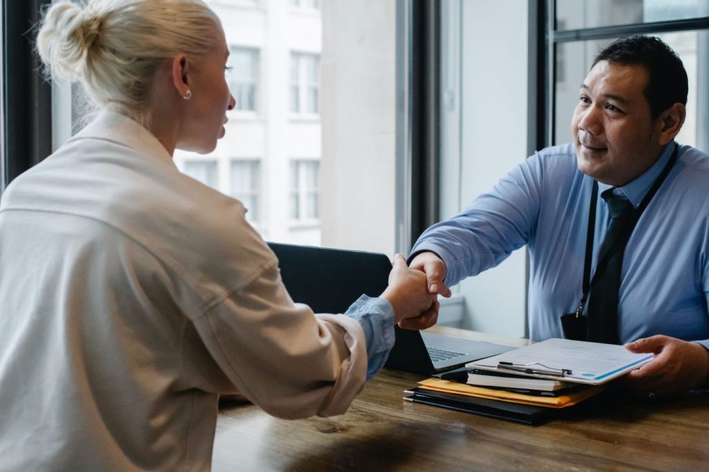 Two people shaking hands celebrating their business partnership.