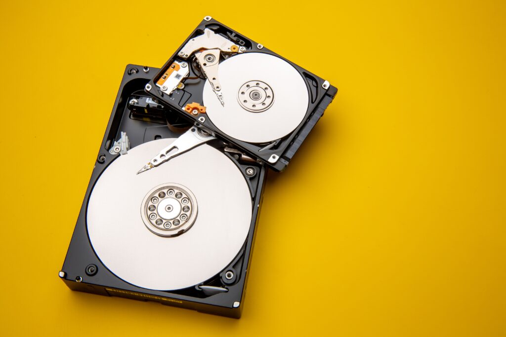 A hard disk with opened covers on a yellow background.