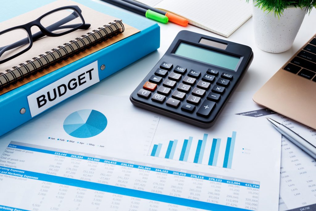 Financial and budget planning concept with calculator notebook and financial chart report on work desk. Represents HR software cost.