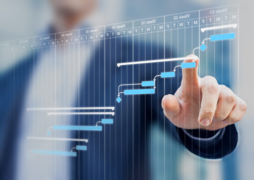 Project manager updating tasks and milestones progress planning with Gantt chart scheduling interface on a virtual screen. Represents critical path method.