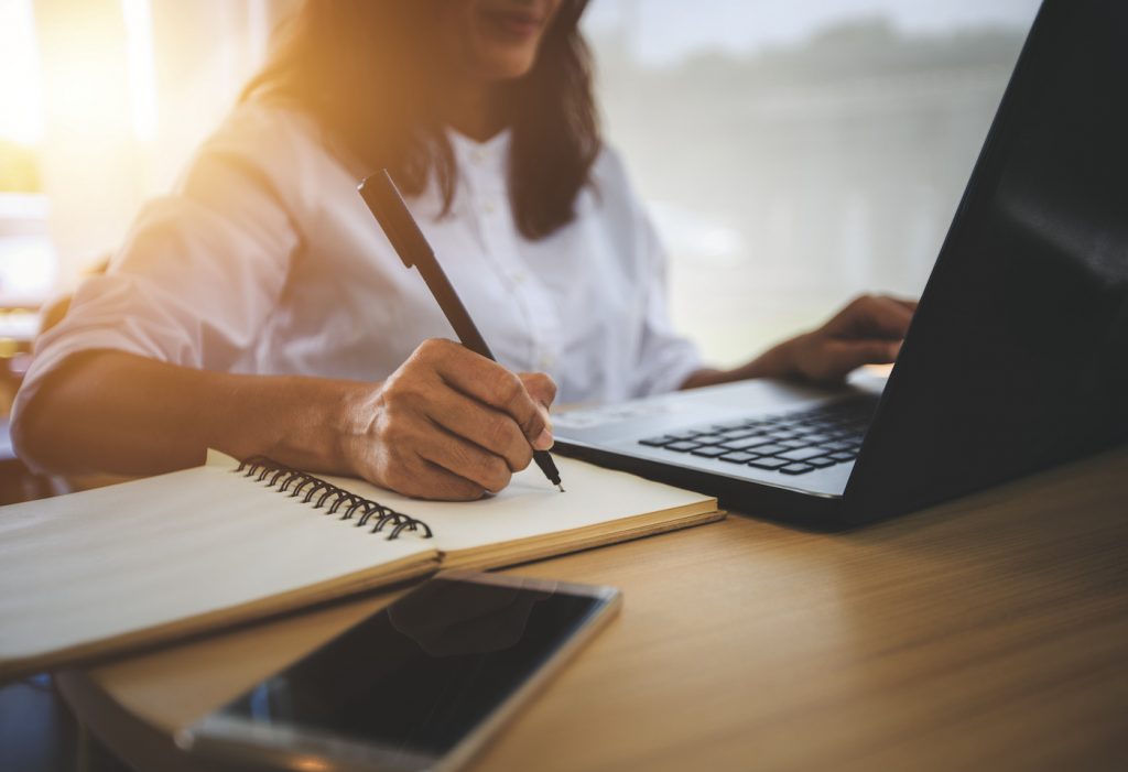 Business person works at a laptop. Represents online learning and training using an LMS for small business.