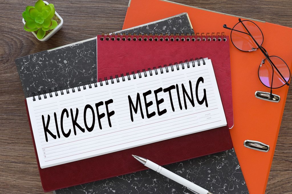 Kickoff Meeting. diary with text on orange folder.