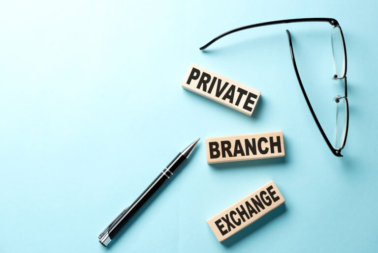 Private Branch Exchange written in wooden blocks with a pen and eyeglass beside.