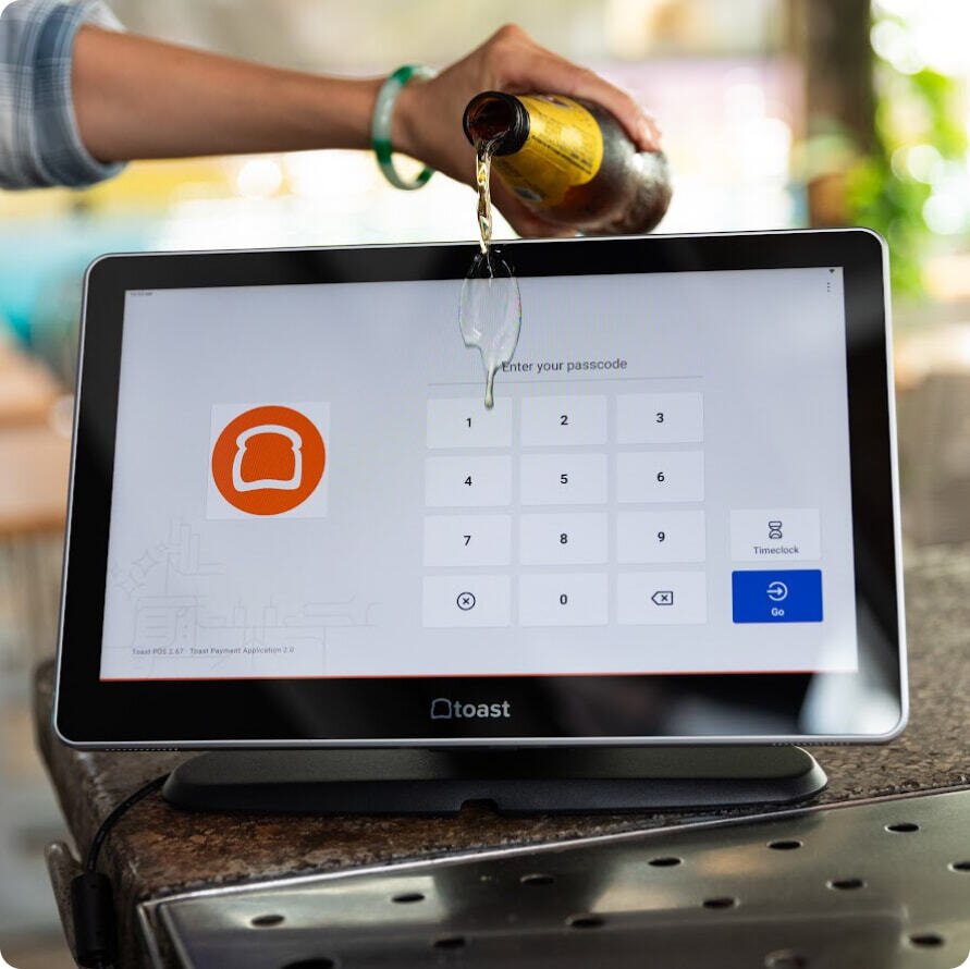 Server pouring beer on a Toast POS screen