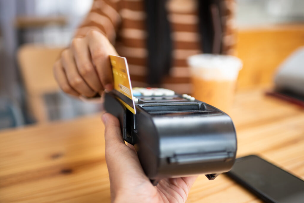 Customer using her credit card to pay her bill.