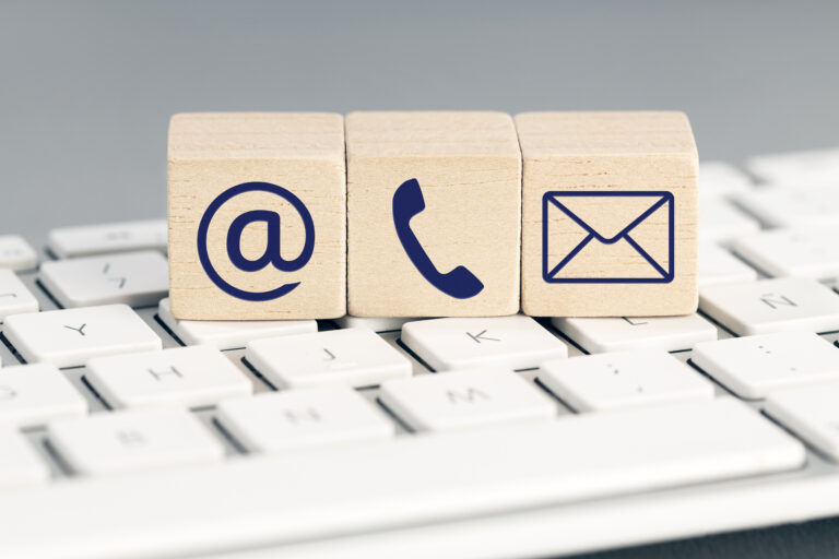 Contact us icons on wooden blocks on top of computer keyboard.