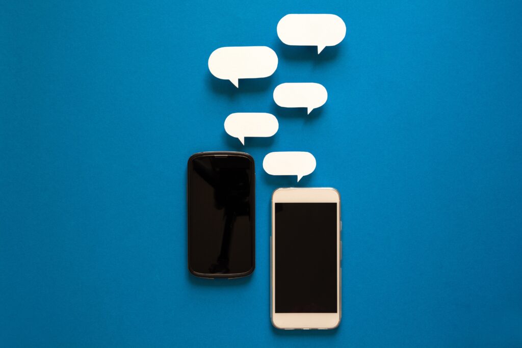 Smartphones with paper speech bubbles on blue background.