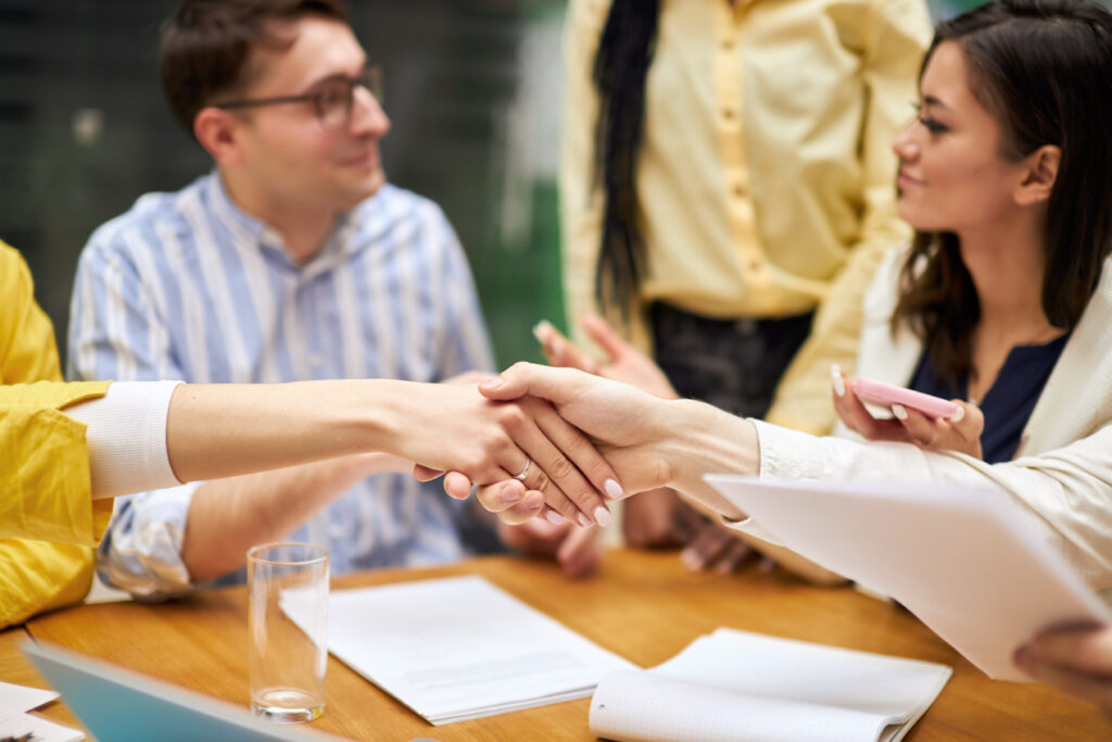 A group of business people acknowledging each other and shaking hands after a meeting.