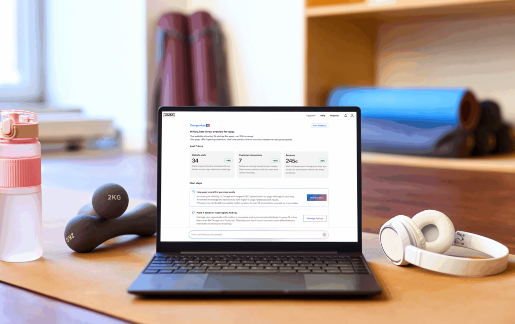 Gym setting with a laptop featuring the Jimdo Companion AI with website analytics.
