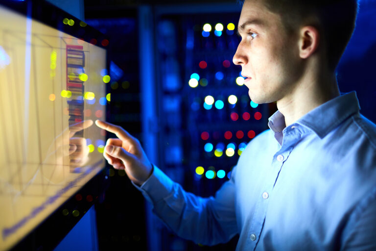 A business employee managing data through a computer screen.