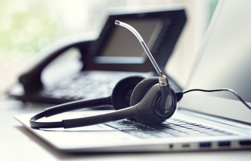Headset headphones telephone and laptop in call center.