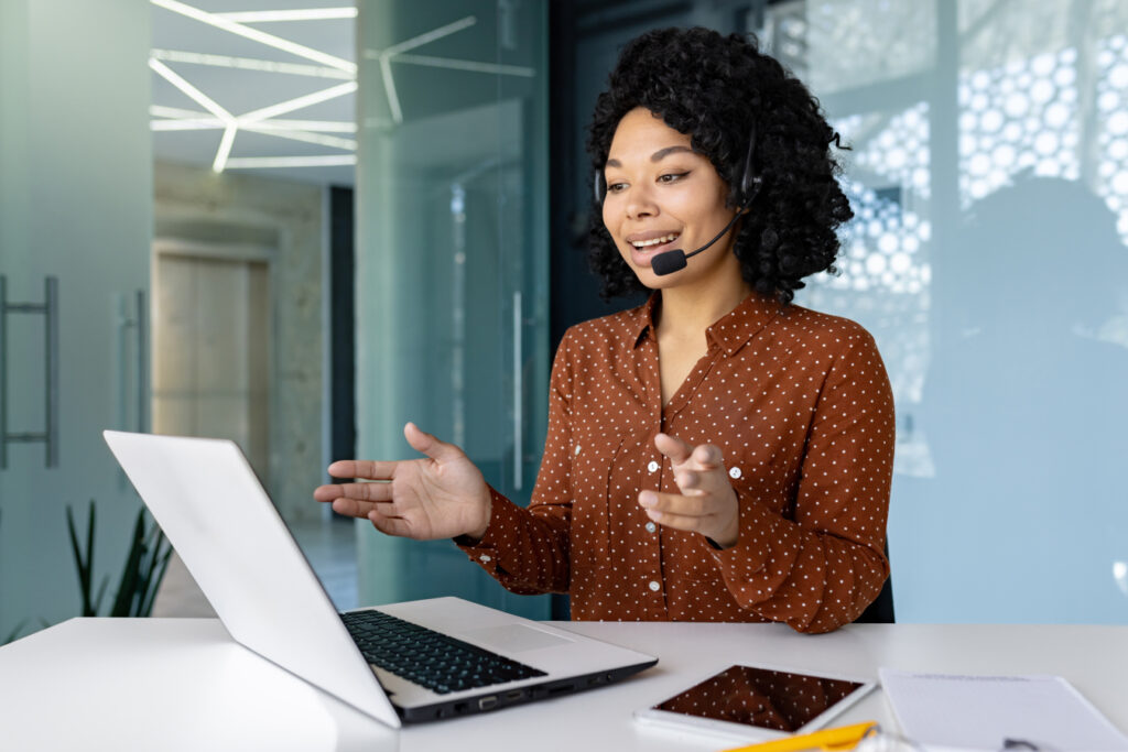 Young beautiful woman talking to customers remotely.