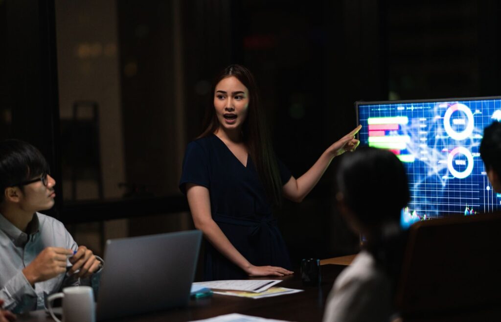 businessmen and businesswomen meeting brainstorming ideas in small modern night office.