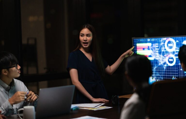 businessmen and businesswomen meeting brainstorming ideas in small modern night office.