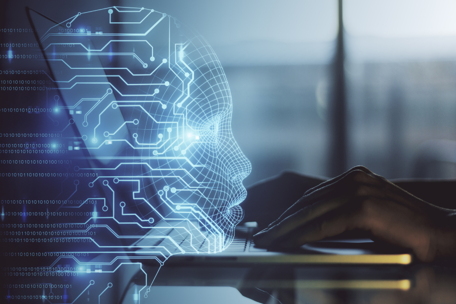 Side view of hands working on a laptop with overlay hologram of an AI humanoid head.