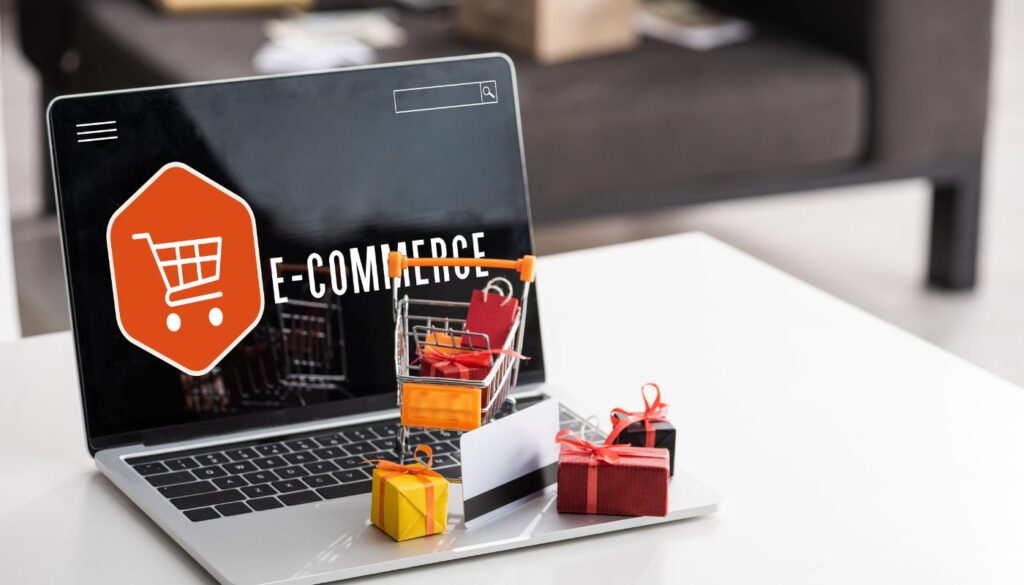 gift boxes and credit card on laptop with e-commerce lettering on laptop screen