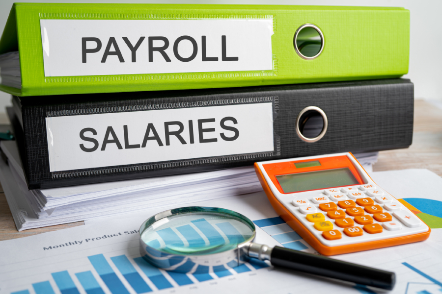 Payroll and salary binder with magnifying glass and calculator.