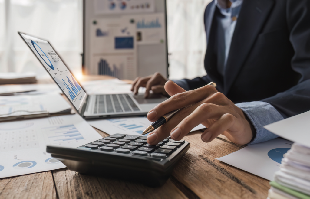 Best accounting software for mid-sized businesses being used by a professional analyzing financial charts on a laptop and calculator.