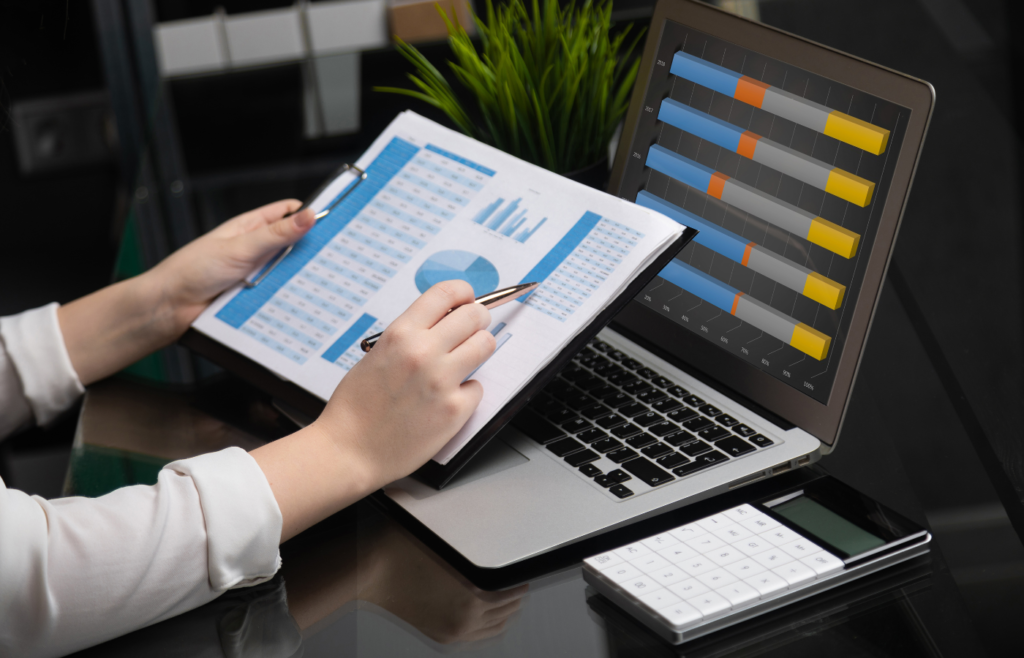 Best multi-entity accounting software displayed on a laptop with an accountant analyzing consolidated financial charts and data spreadsheets.