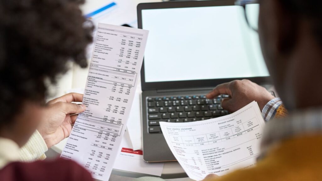 Reviewing Business Finances With Laptop and Statement