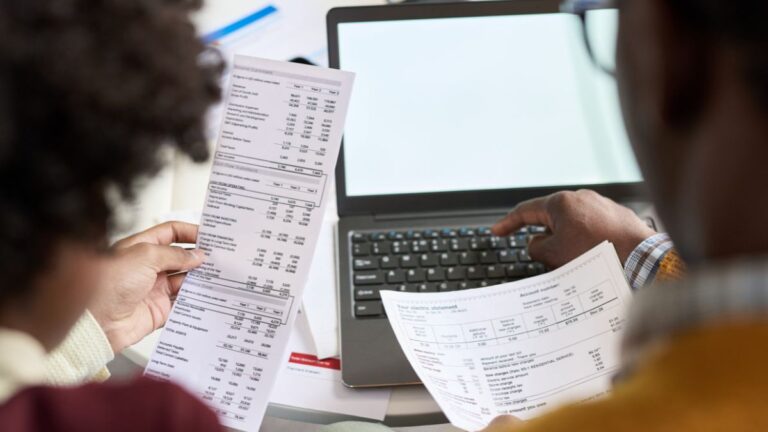 Reviewing Business Finances With Laptop and Statement