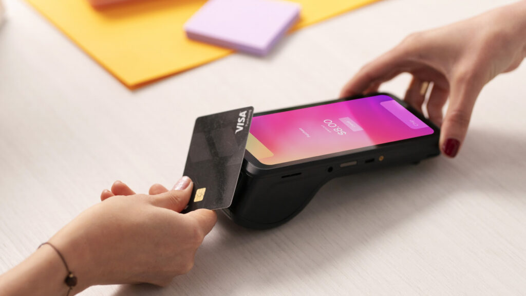 Customer inserting a Visa card into the Helcim Smart Terminal at checkout.