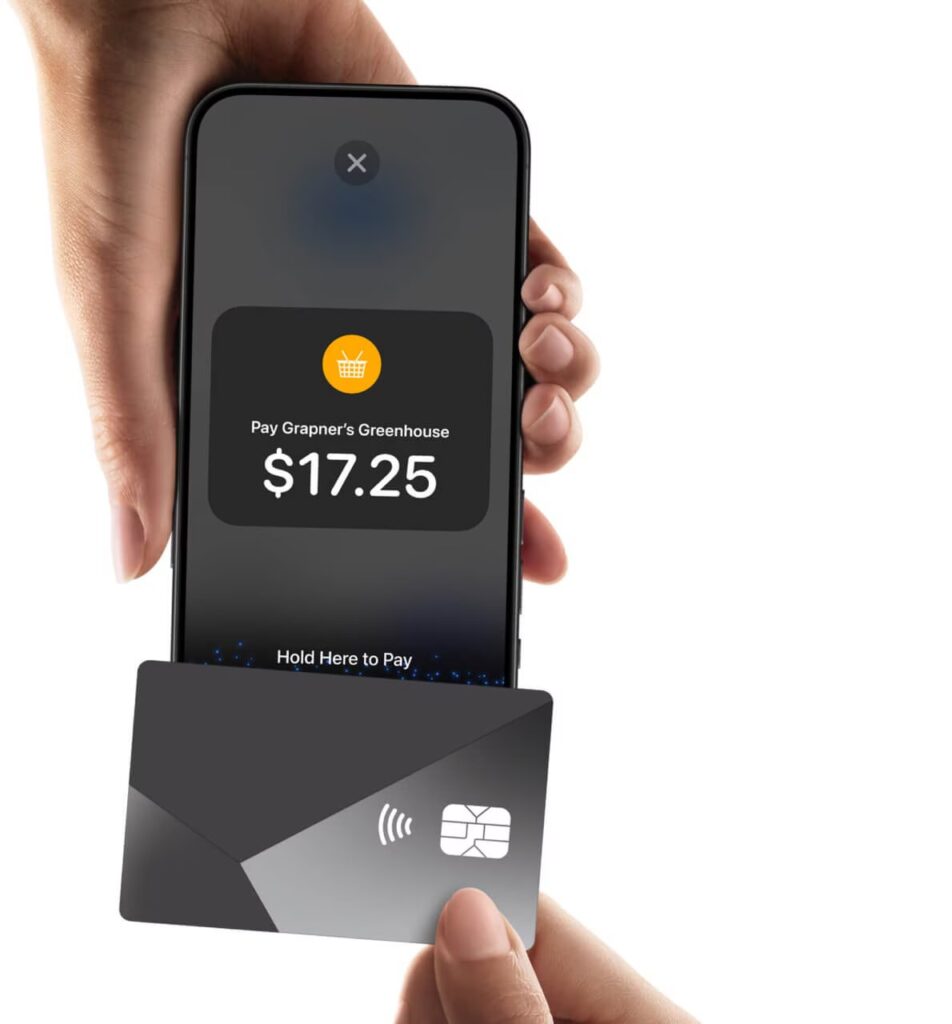 Customer holding a contactless card near an iPhone displaying a QuickBooks payment request.